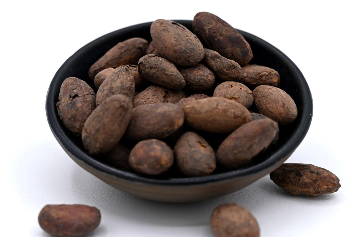 Fèves de cacao entières dans un bol noir