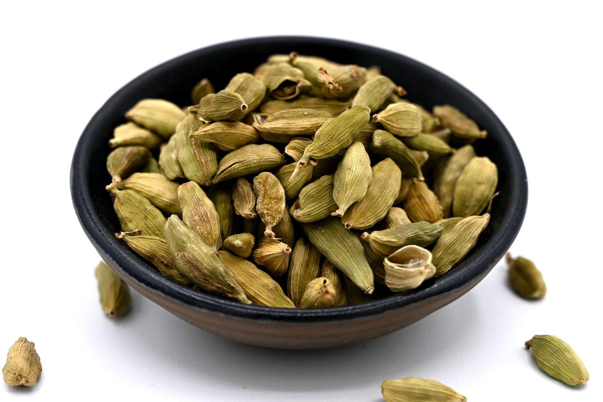 Gousses de cardamome verte dans un bol noir