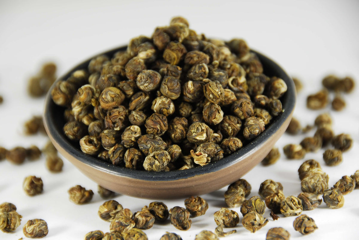 Perles de thé blanc au jasmin dans un bol noir