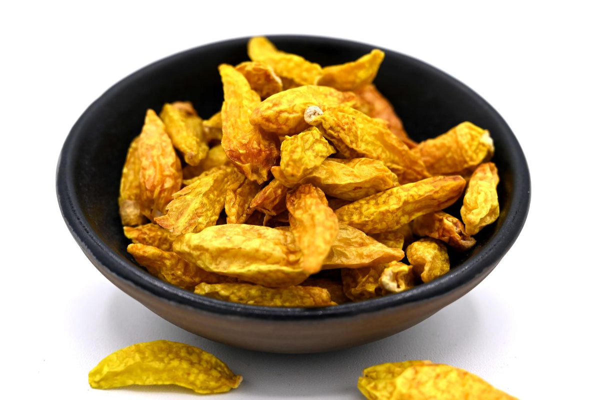Morceaux de piment jaune séché dans un bol noir