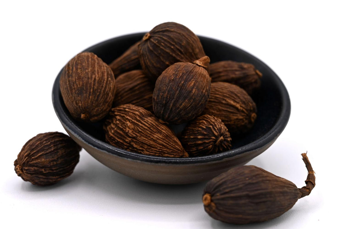 Gousses de cardamome noire dans un bol noir